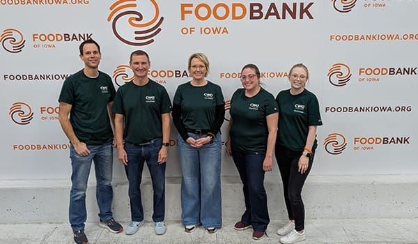 Group of people posing for photo in front of Food Bank of Iowa backdrop