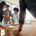 team gathered around table discussing business operations